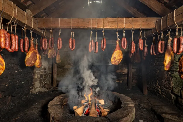 Saucisses de Morteau fumées dans un tuyé traditionnel d'une ferme comtoise